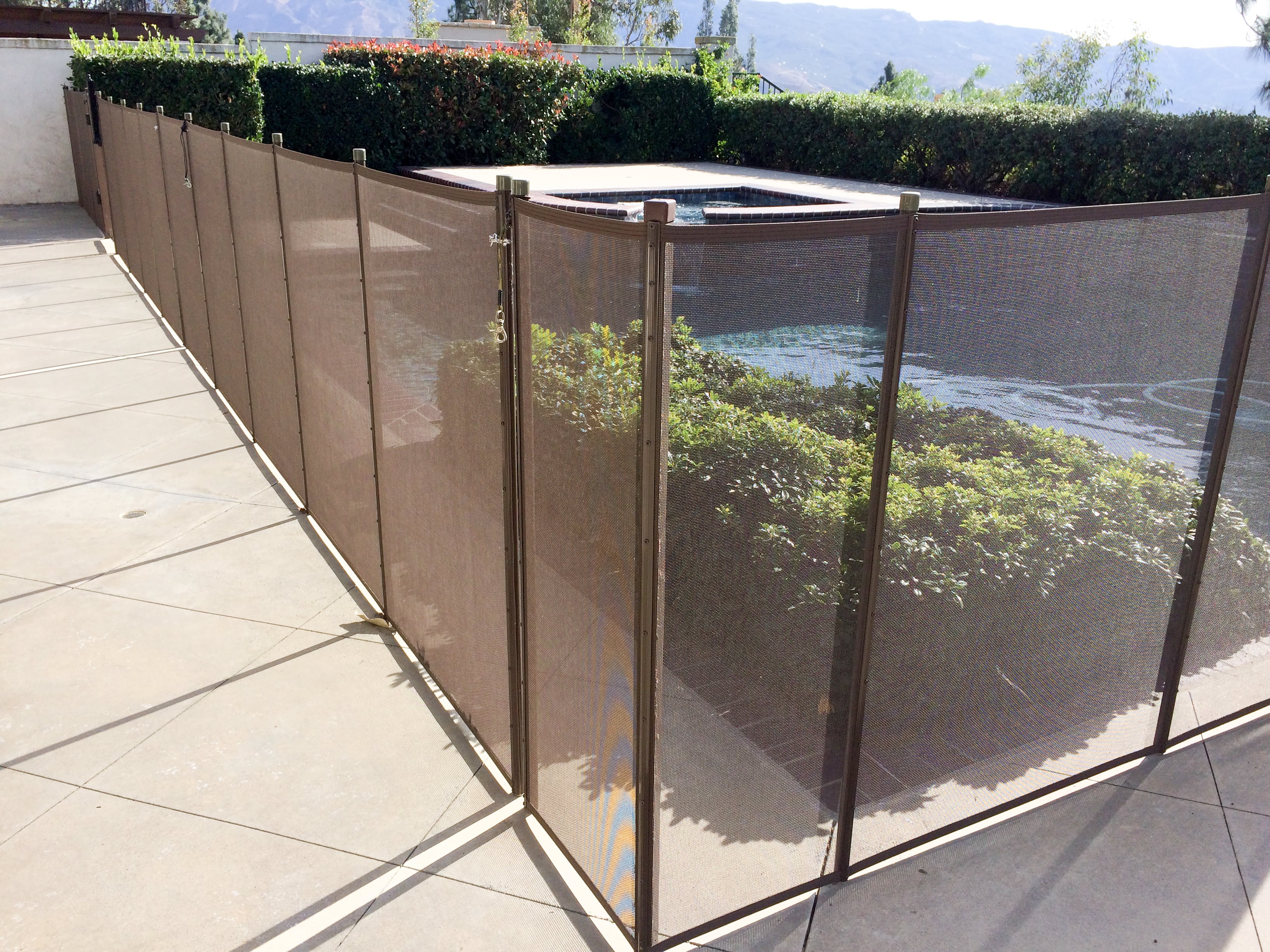 A mesh wall fence around an inground pool