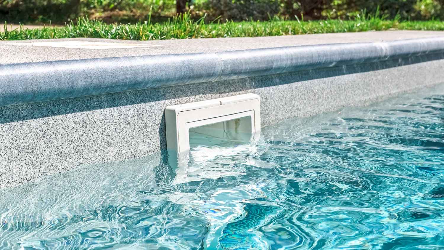 In-ground pool skimmer half-way covered with water
