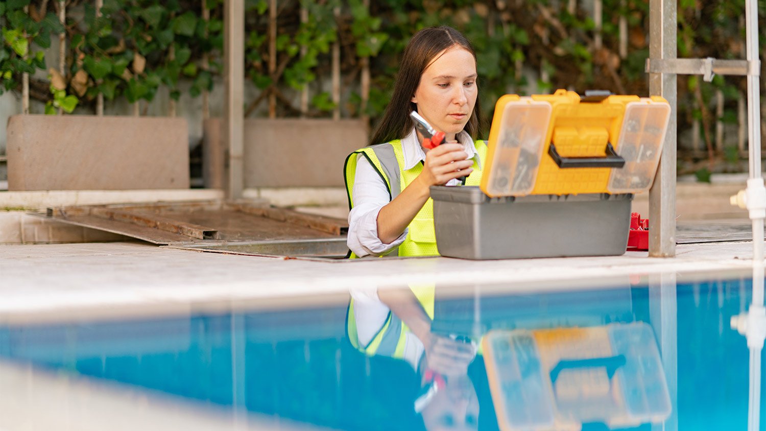 Female maintenance worker checking and fixing pipes and water pumping machines