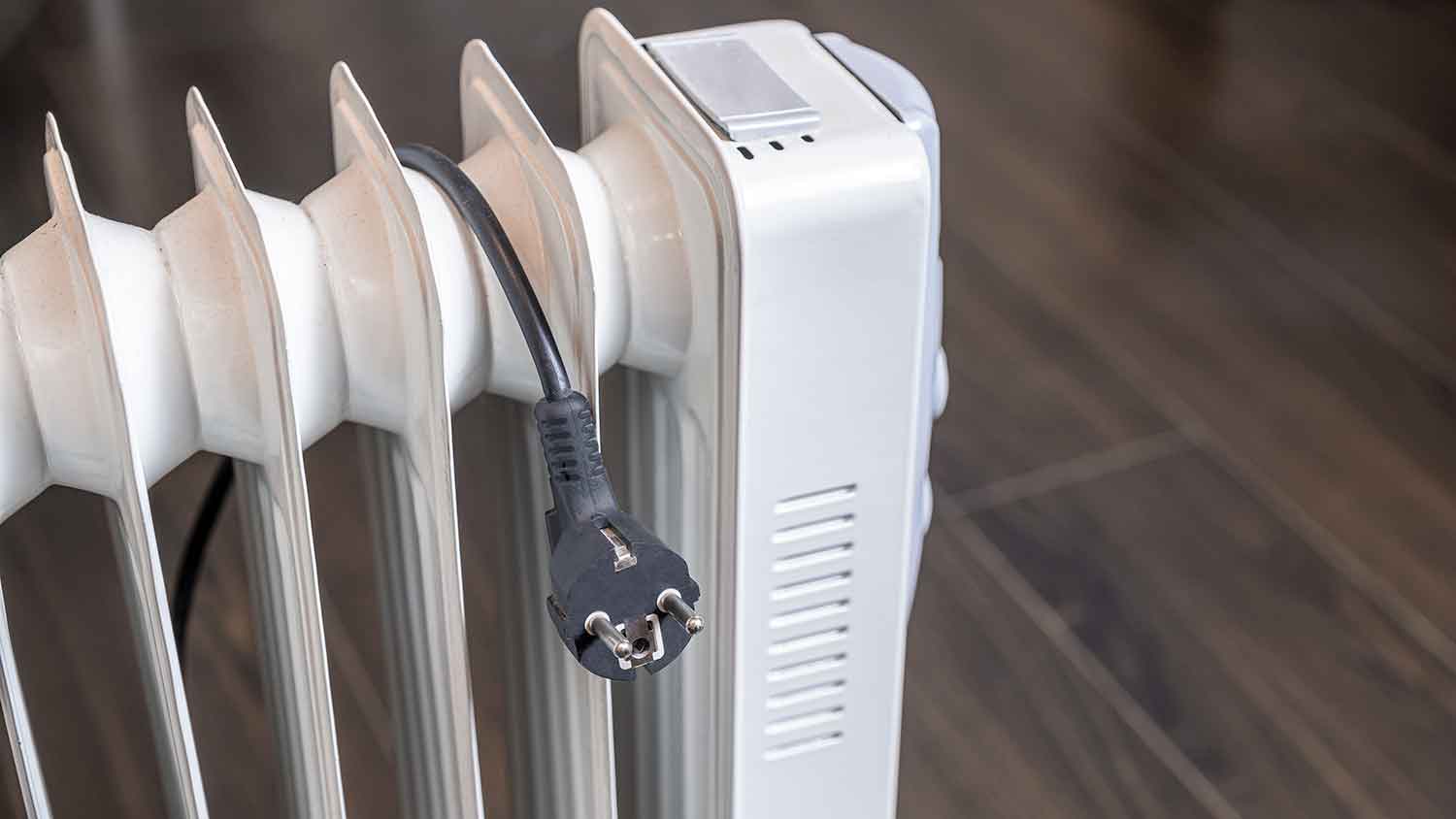 Power cord hanging on top of an electric radiator