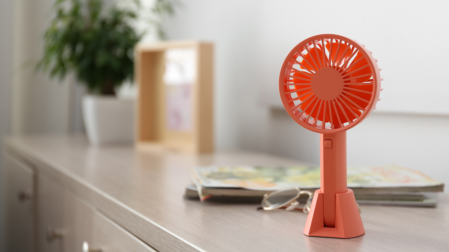 Modern portable hand fan on dresser