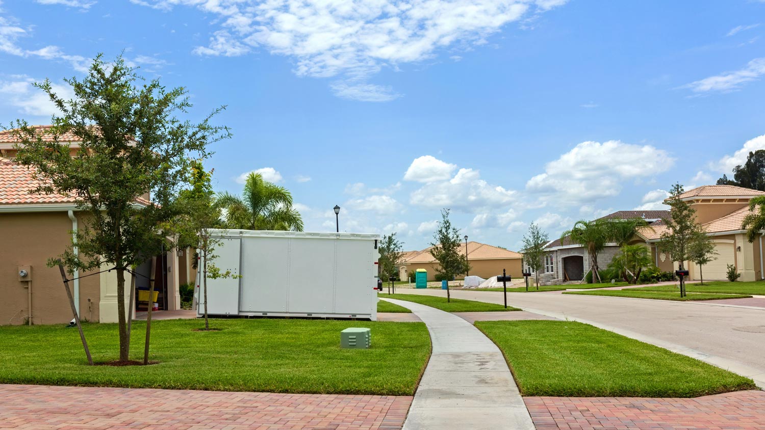 A portable storage unit in the driveway of a house