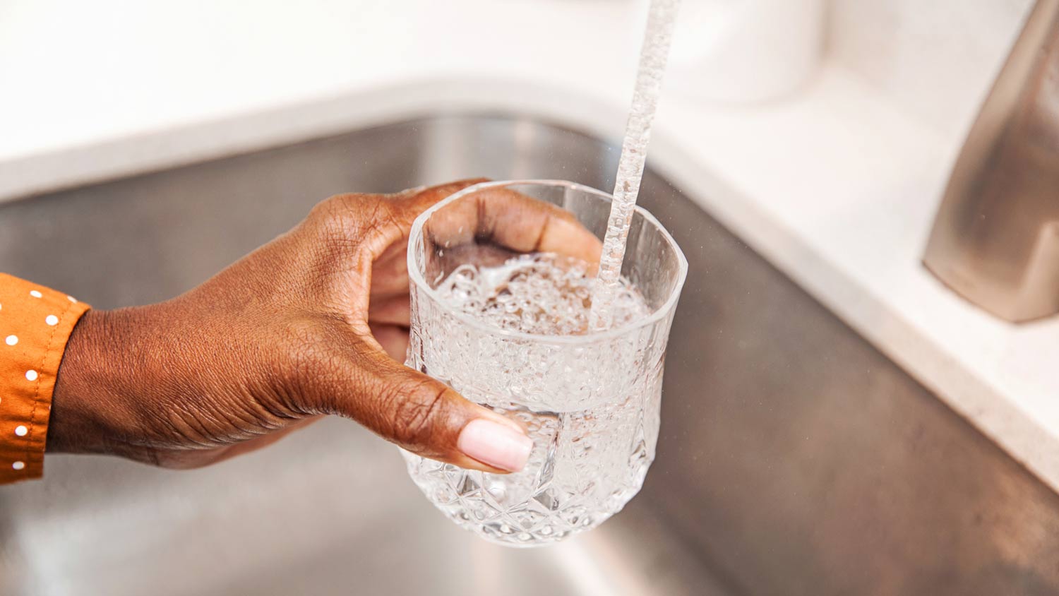 woman pouring a glass of tap water