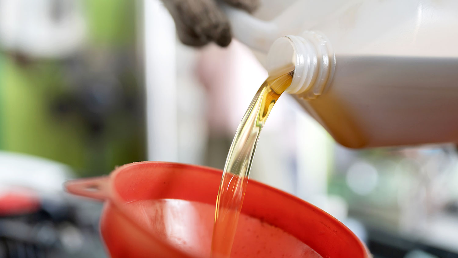 Closeup of a person pouring engine oil