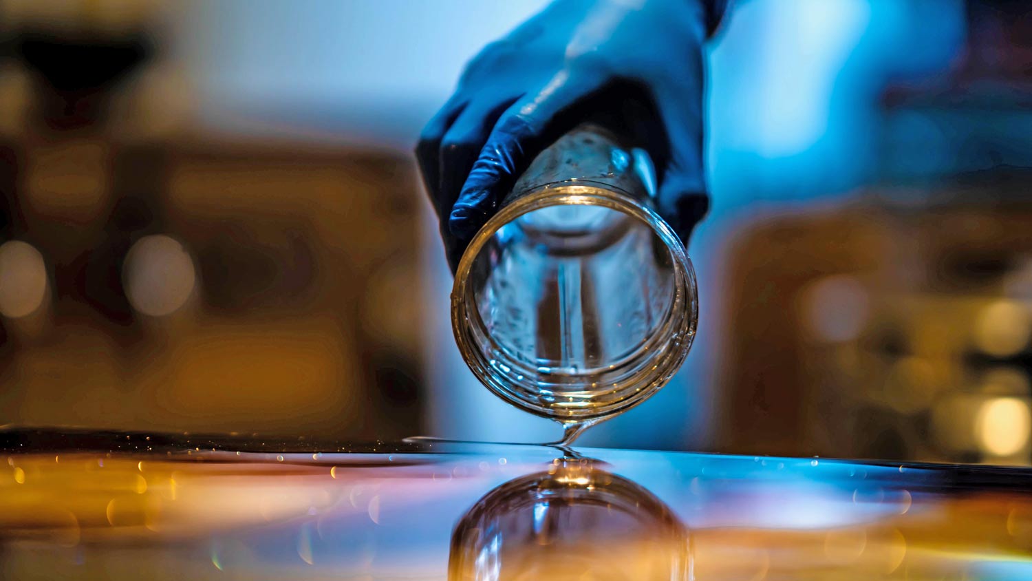 person pouring epoxy onto table  