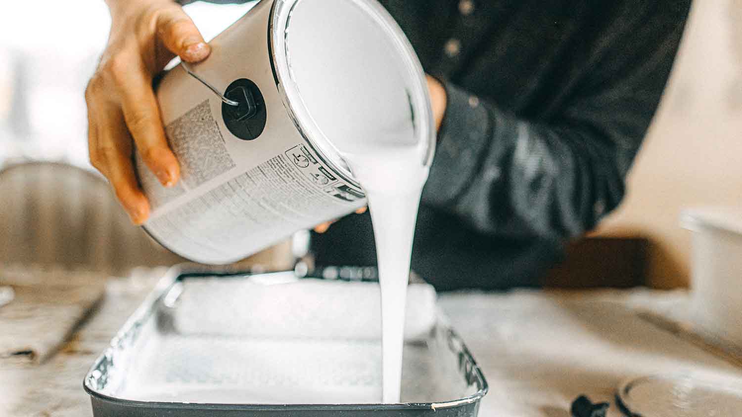 Pouring paint into a roller tray