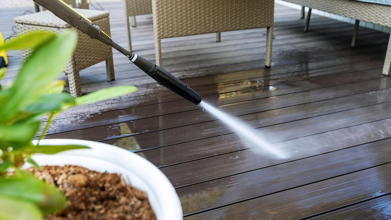 Closeup of power washing a wood deck