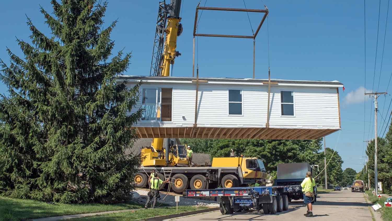 prefab house lifted by carrier truck