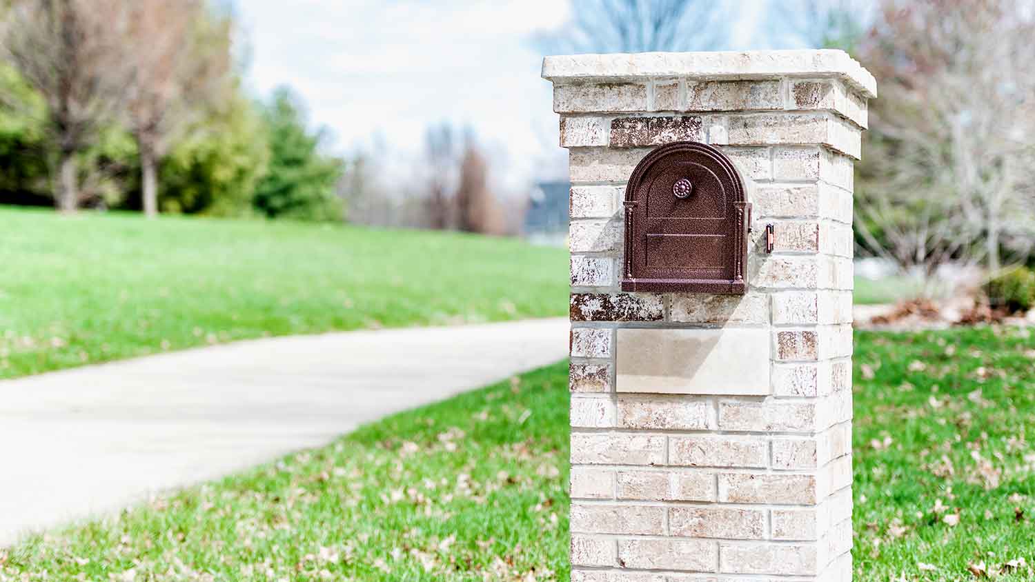 Prefabricated brick mailbox by a sidewalk