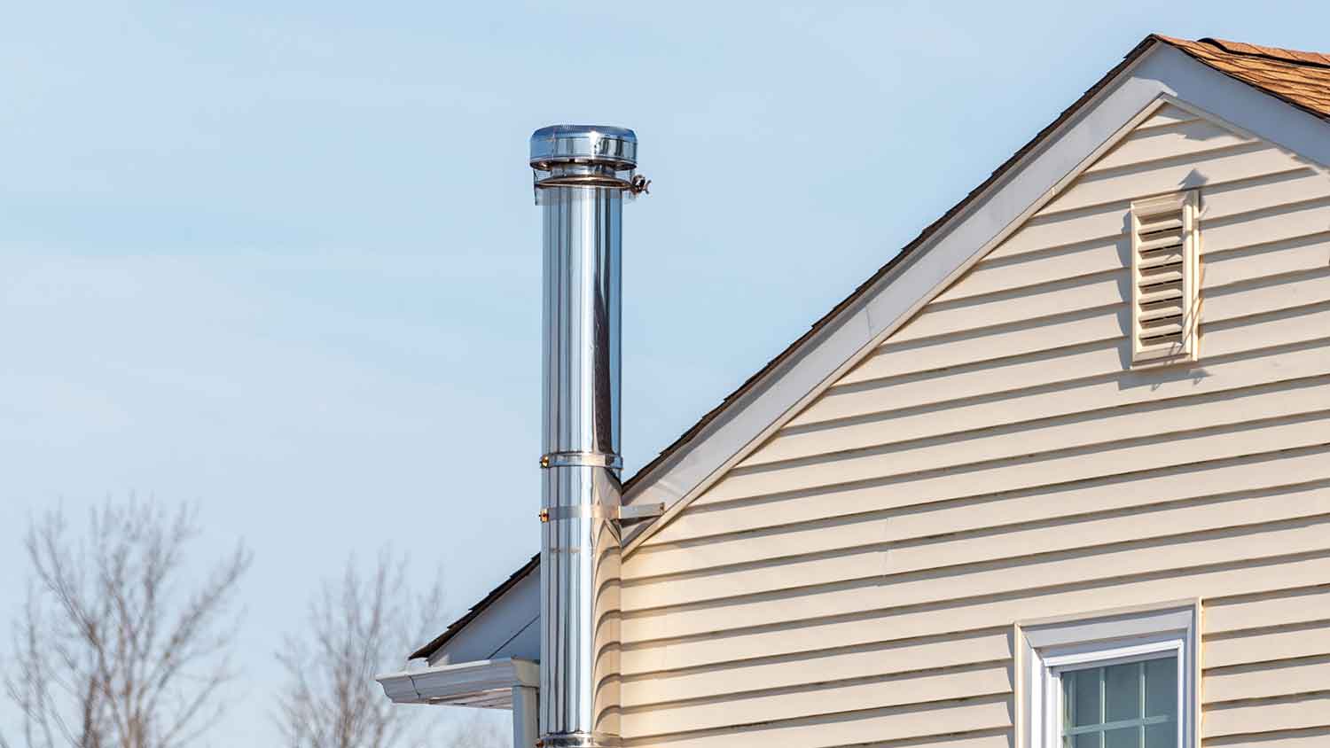 Metal chimney installed next to a house