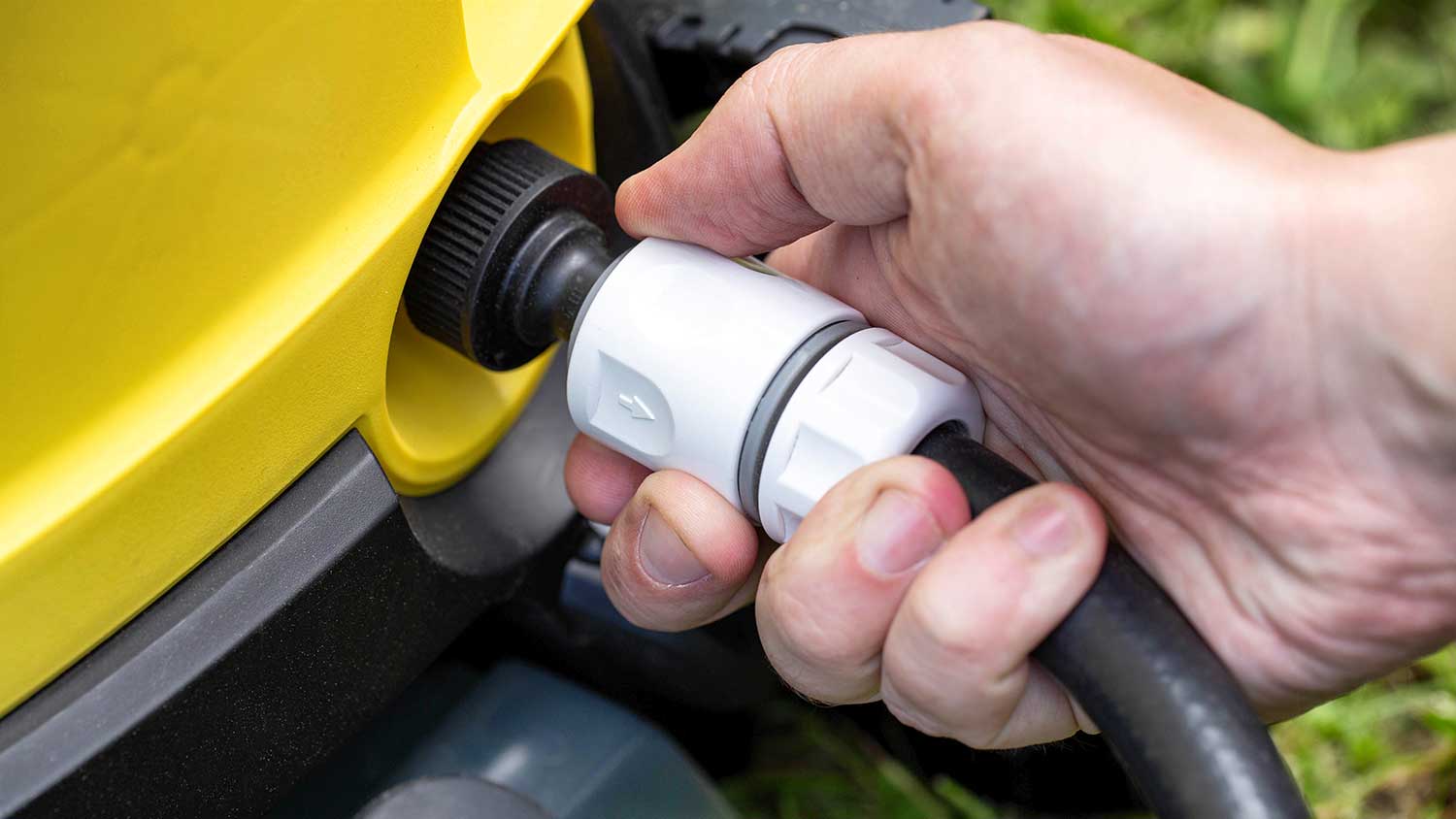 Man checking pressure washer connection