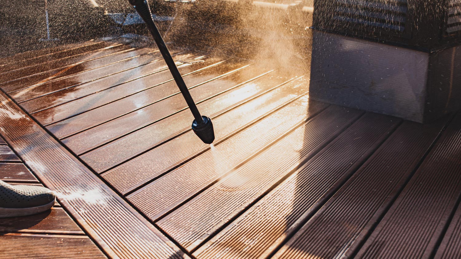 Close-up of pressure washing a wooden deck