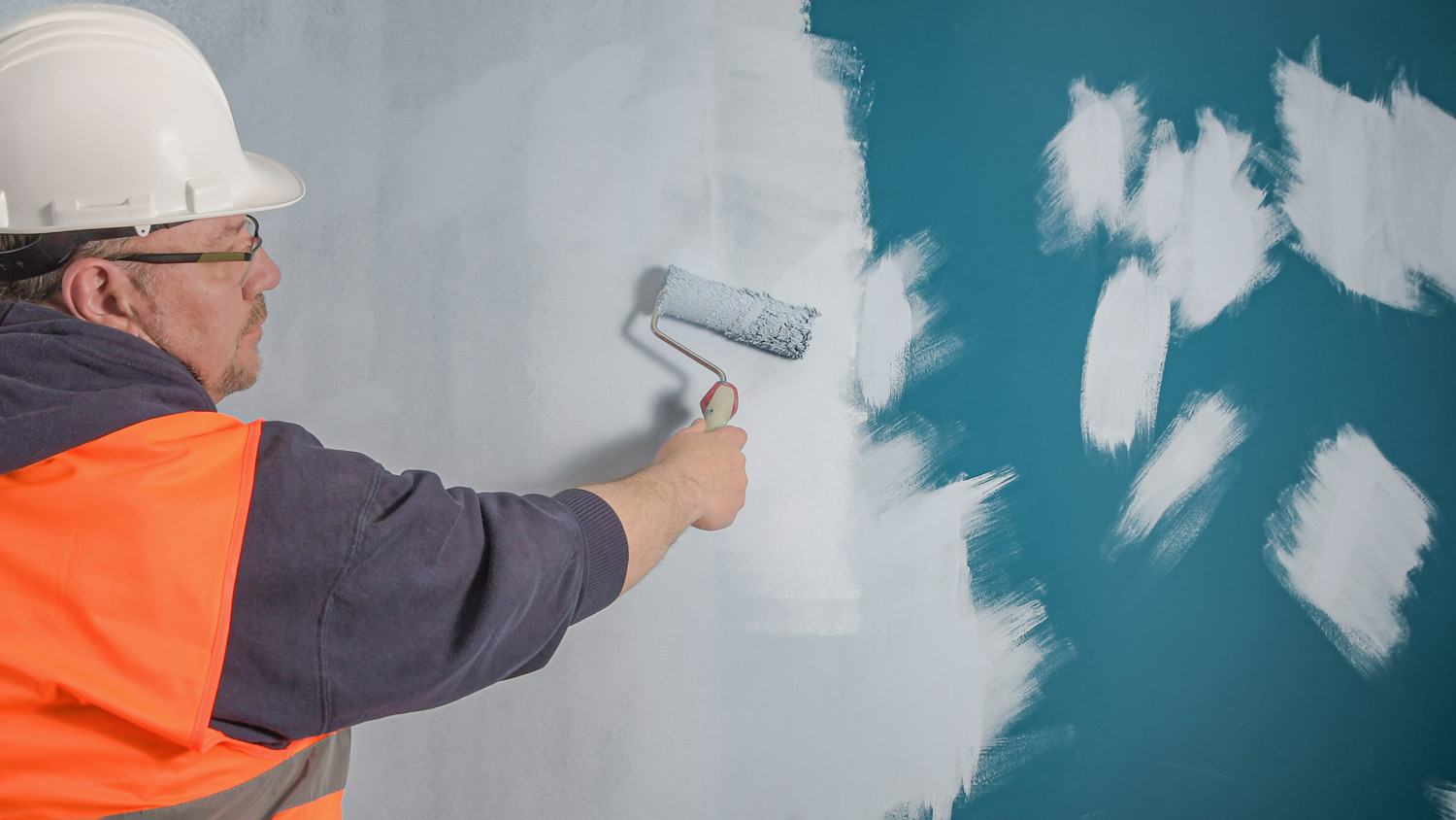 Pre-wiped damage on the wall with the first coat of paint applied. Primer with light paint on a dark wall