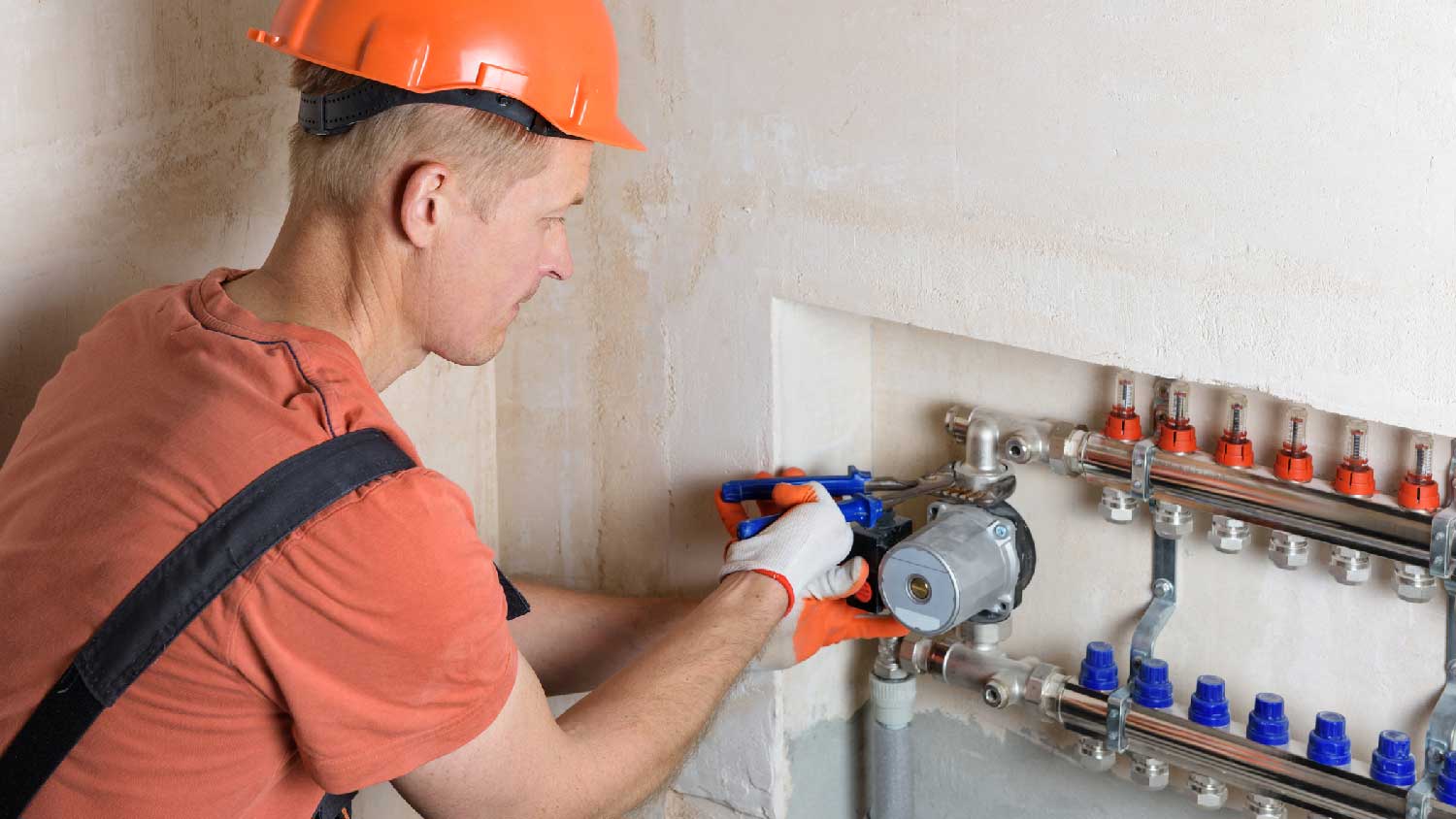 A professional adjusting a geothermal pump system