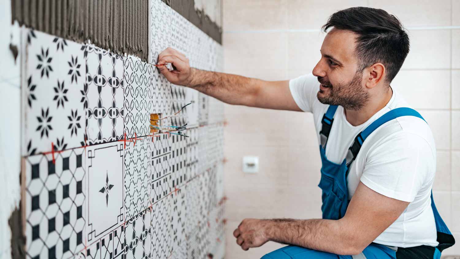 A professional applying ceramic tiles on the wall