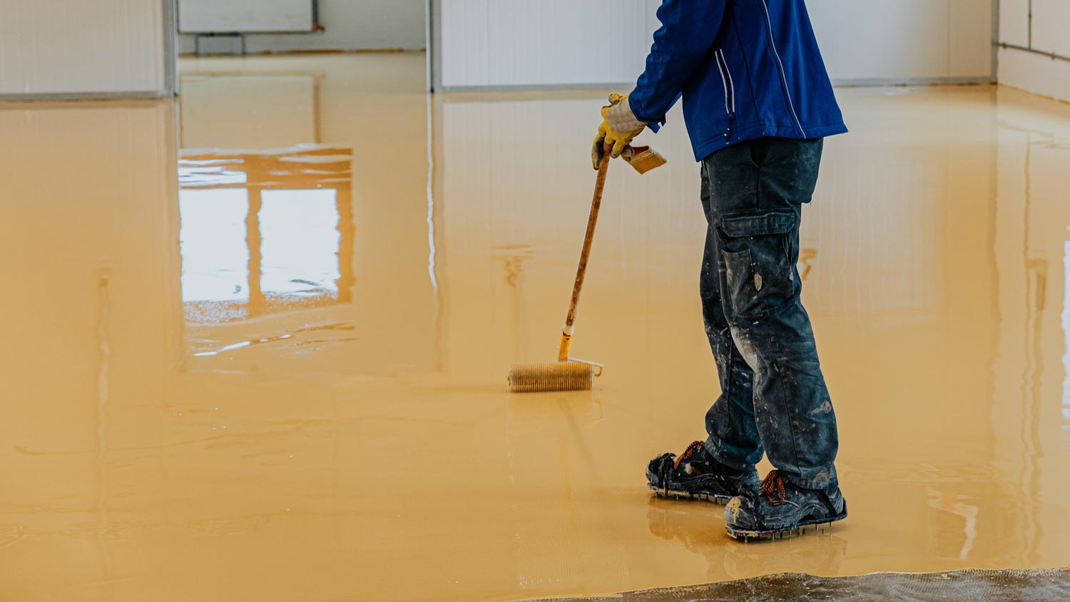 A professional applying epoxy resin on flooring