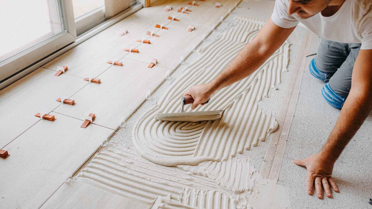 A professional applying thinset on floor