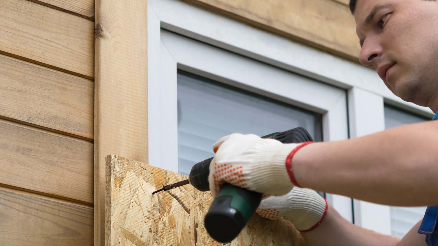 A professional boarding a window with plywood