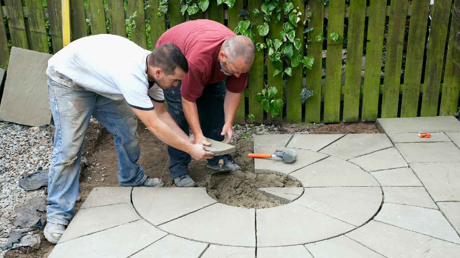 Two professionals building a concrete patio