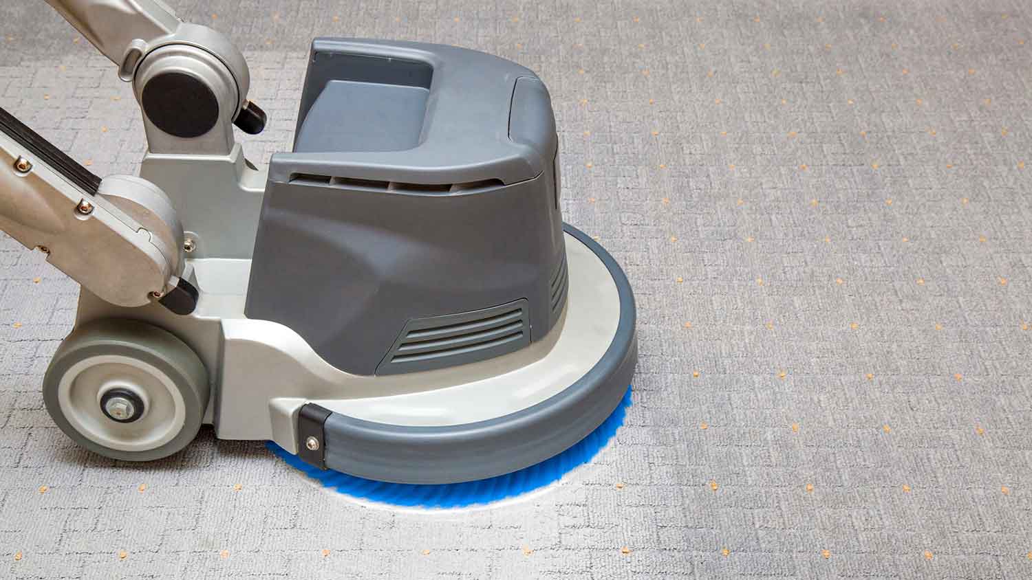 Oscillating carpet cleaning machine on a gray carpet