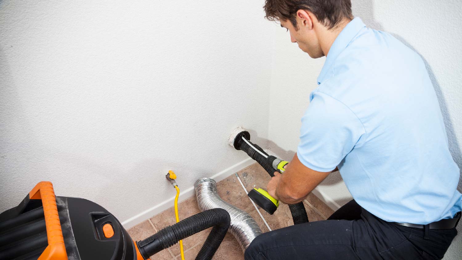 A professional cleaning a dryer vent