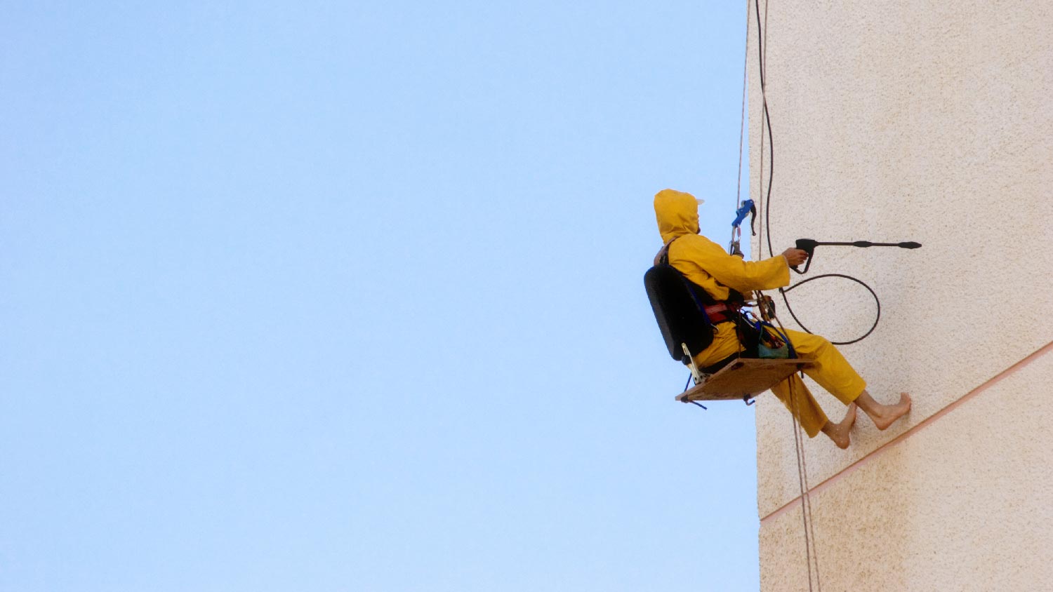 A professional cleaning a house with a sandblaster