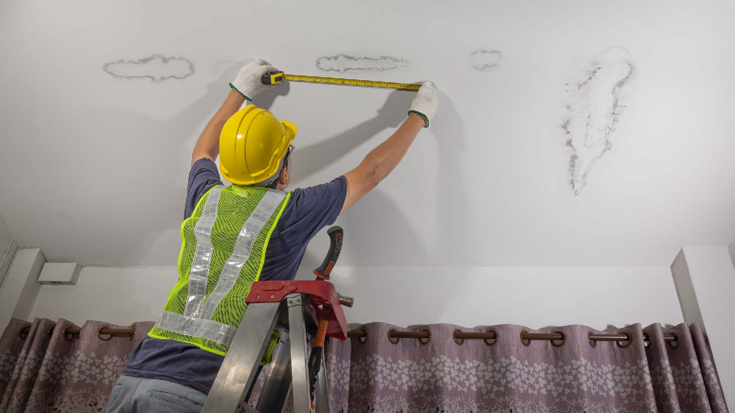 A professional fixing a ceiling leaking problem