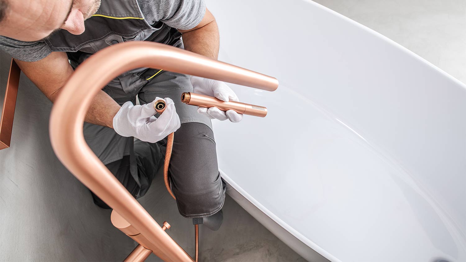 professional installing new bathtub hardware