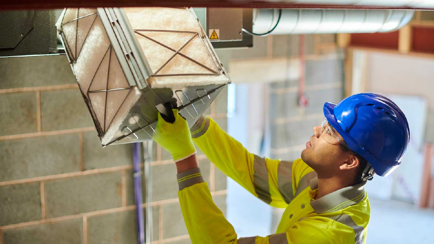 A professional inspecting an air duct