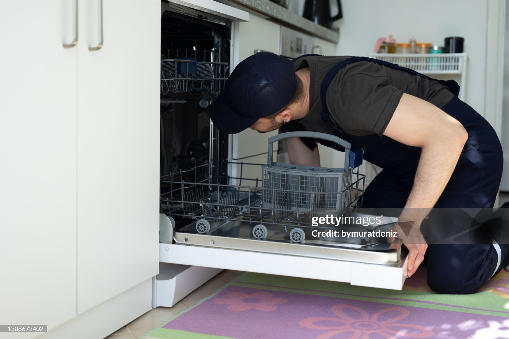 A professional inspecting a dishwasher