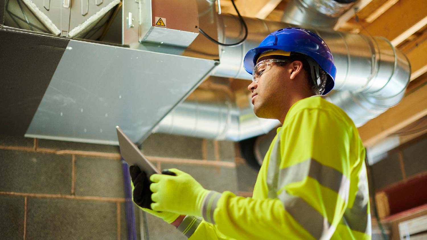 A professional inspecting ductwork on attic