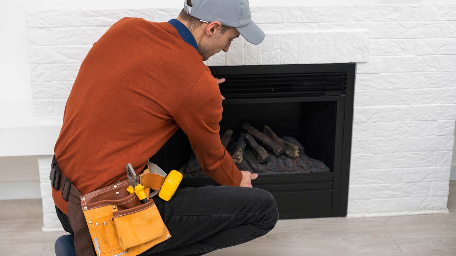 man inspecting gas fireplace