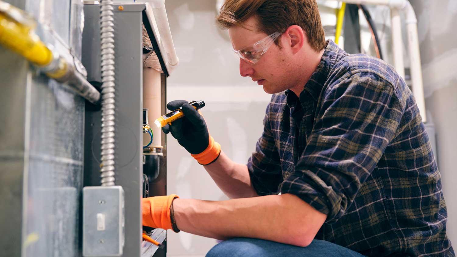 A professional inspecting a furnace