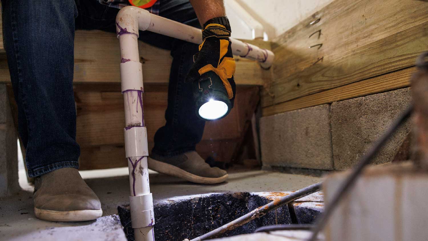 A professional inspecting a sump pump