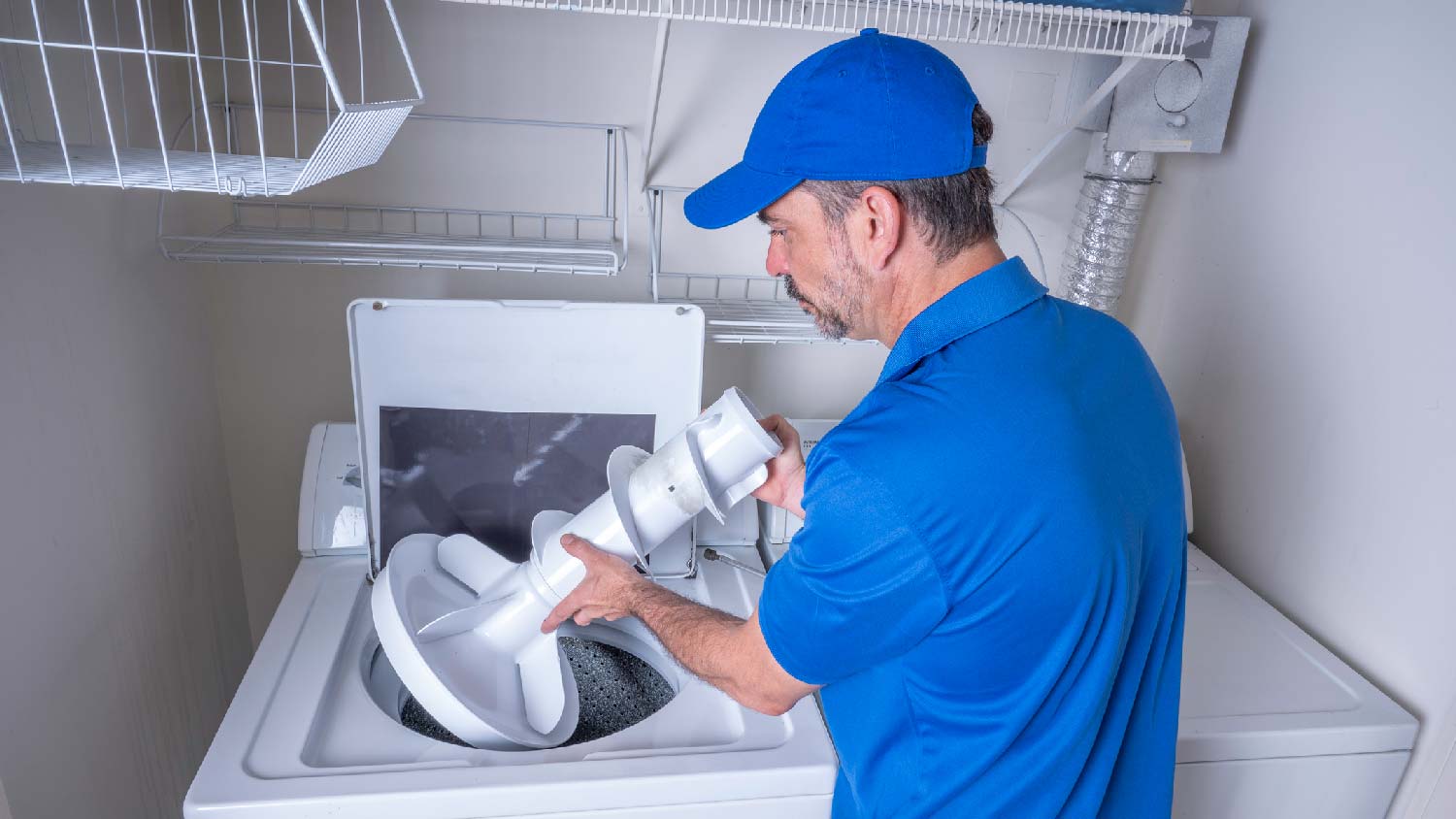 A professional inspecting a washing machine agitator