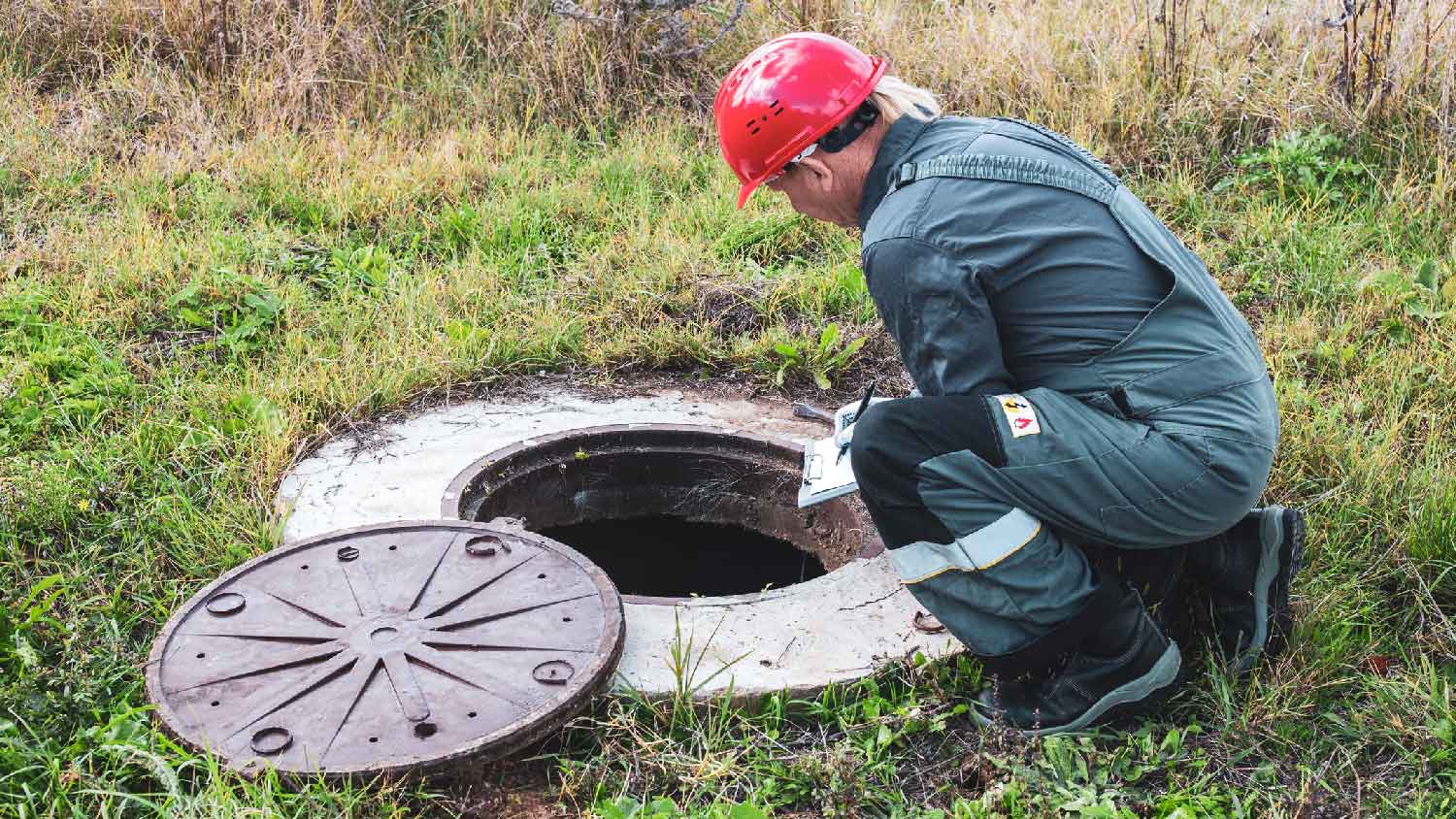 A professional inspecting a water well