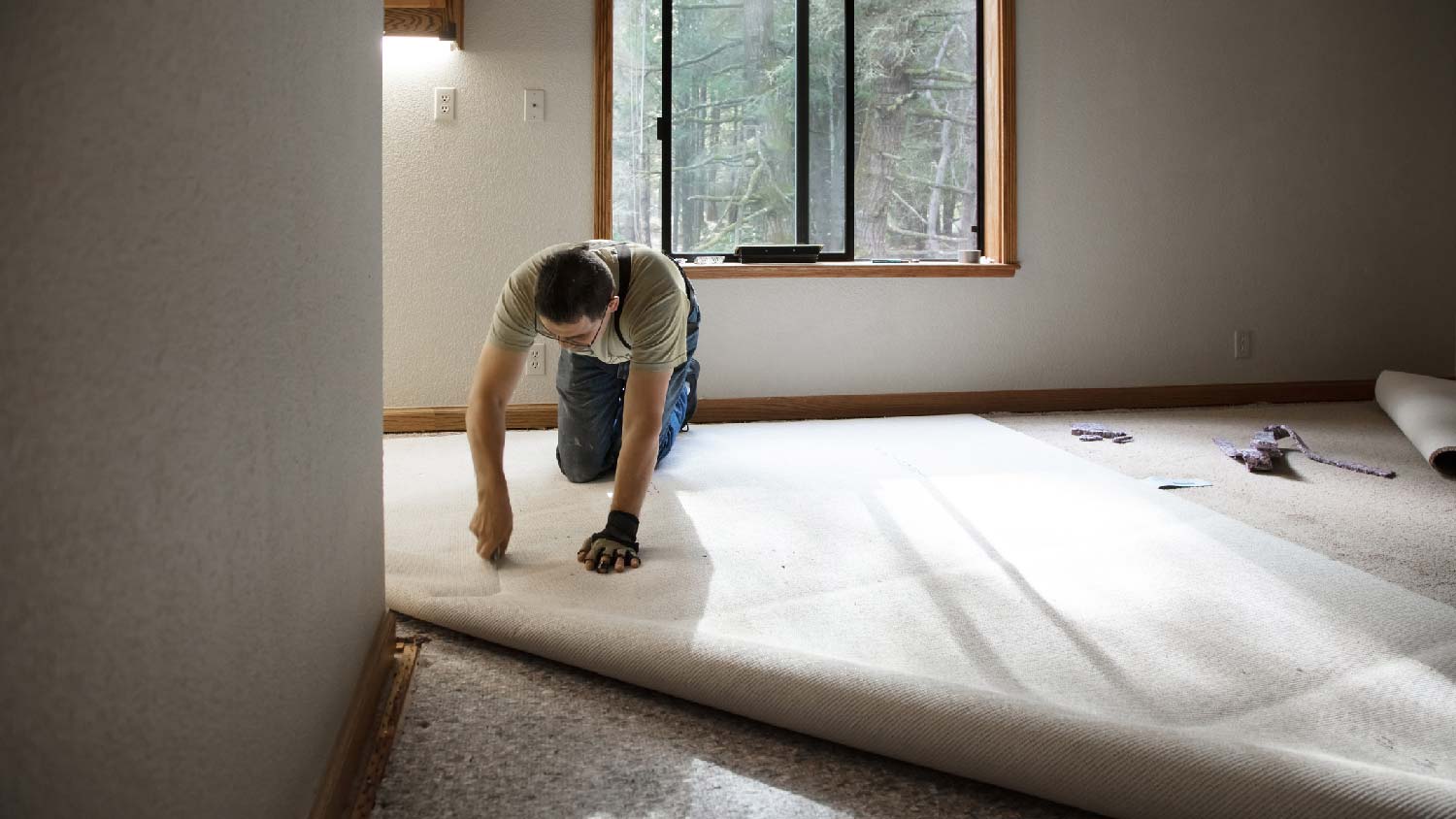 A professional installing carpet with visible padding