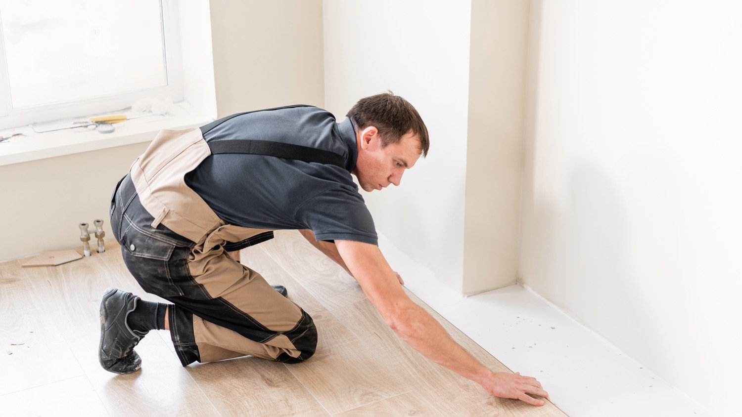 A professional installing new laminate planks