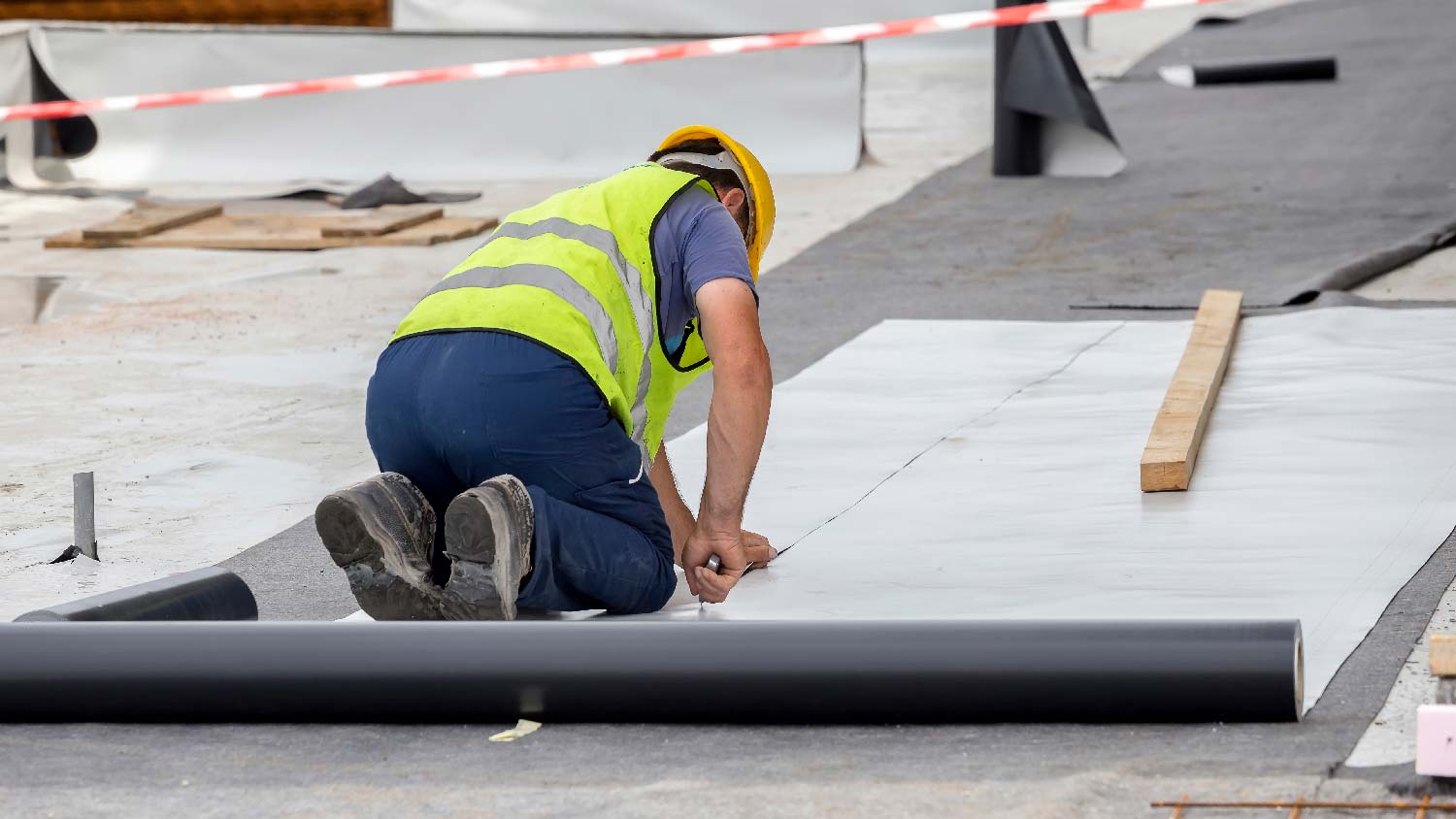 A professional installing synthetic underlayment