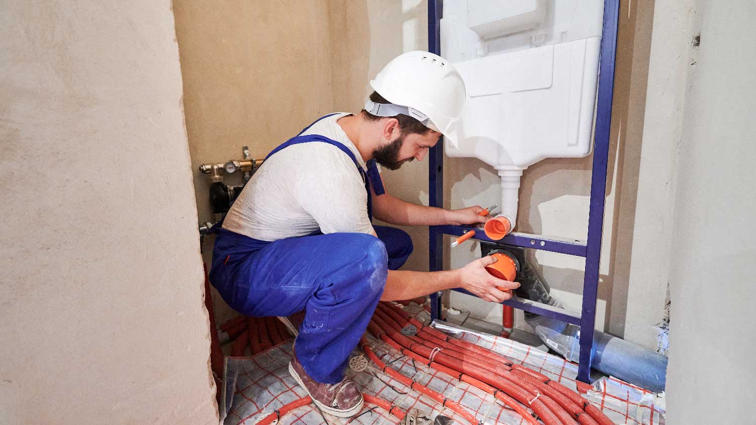 A professional installing a tank for a wall hung toilet