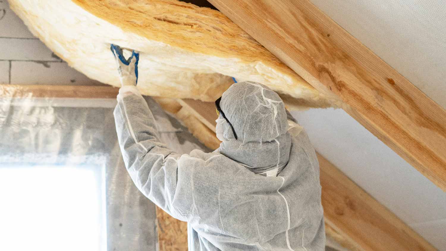 A professional insulating an attic