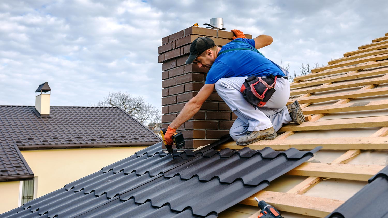 A professional lays tiles on a roof