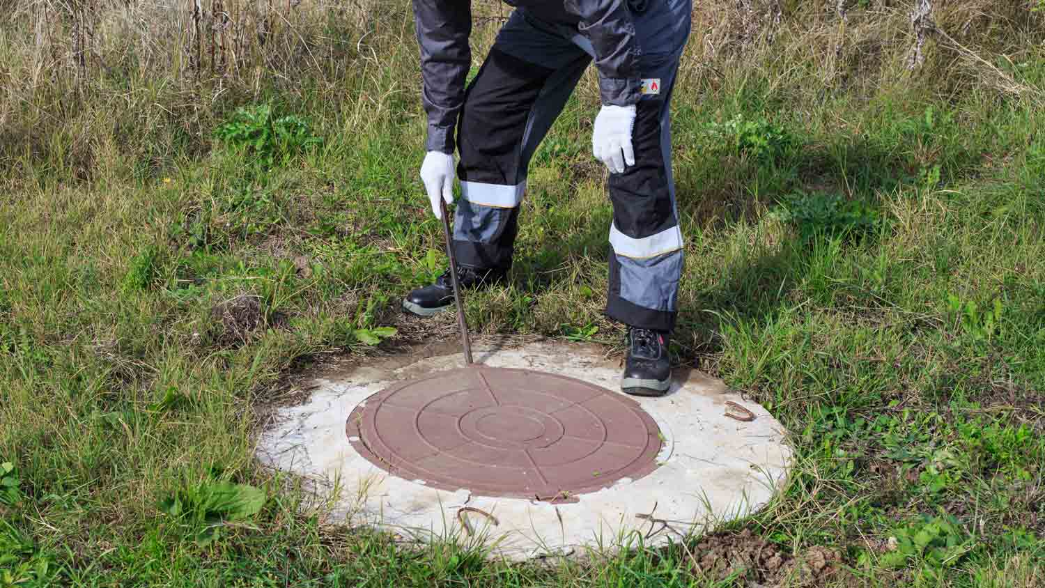 professional plumber opening septic tank