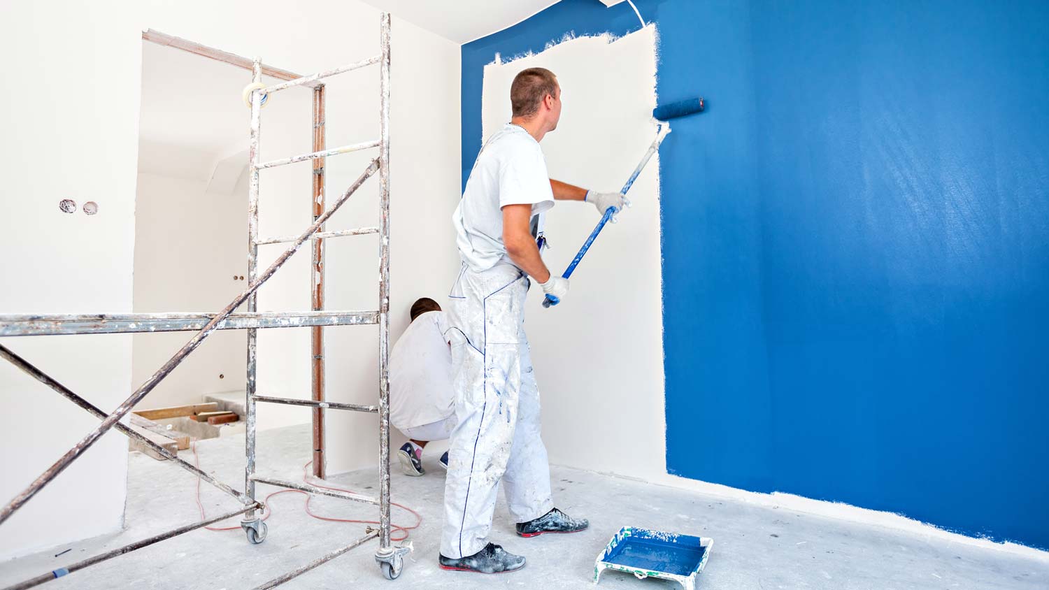 A professional painter painting a room with a roller