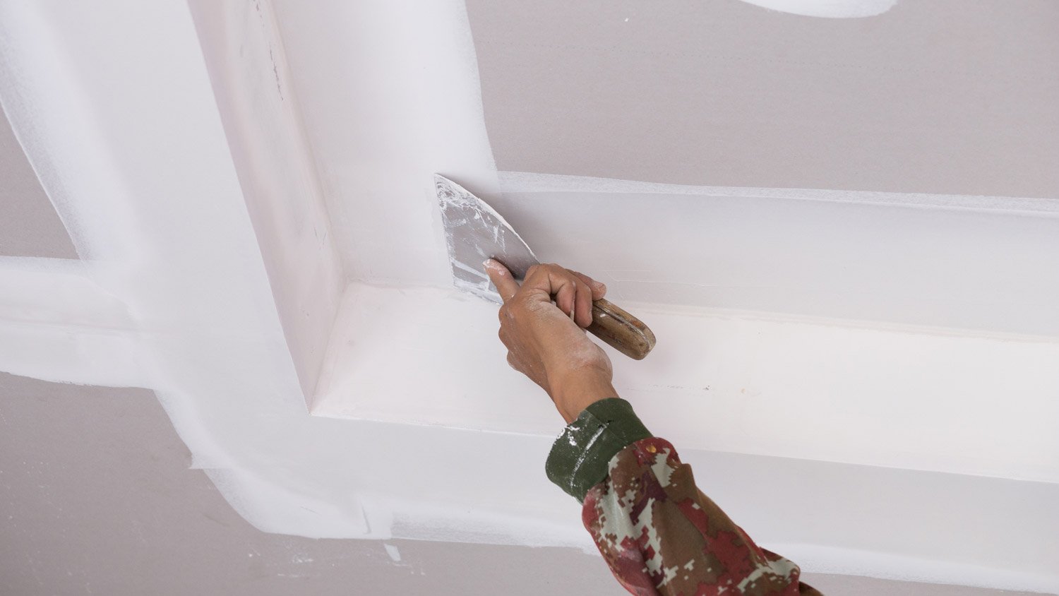 A professional using plaster on the ceiling