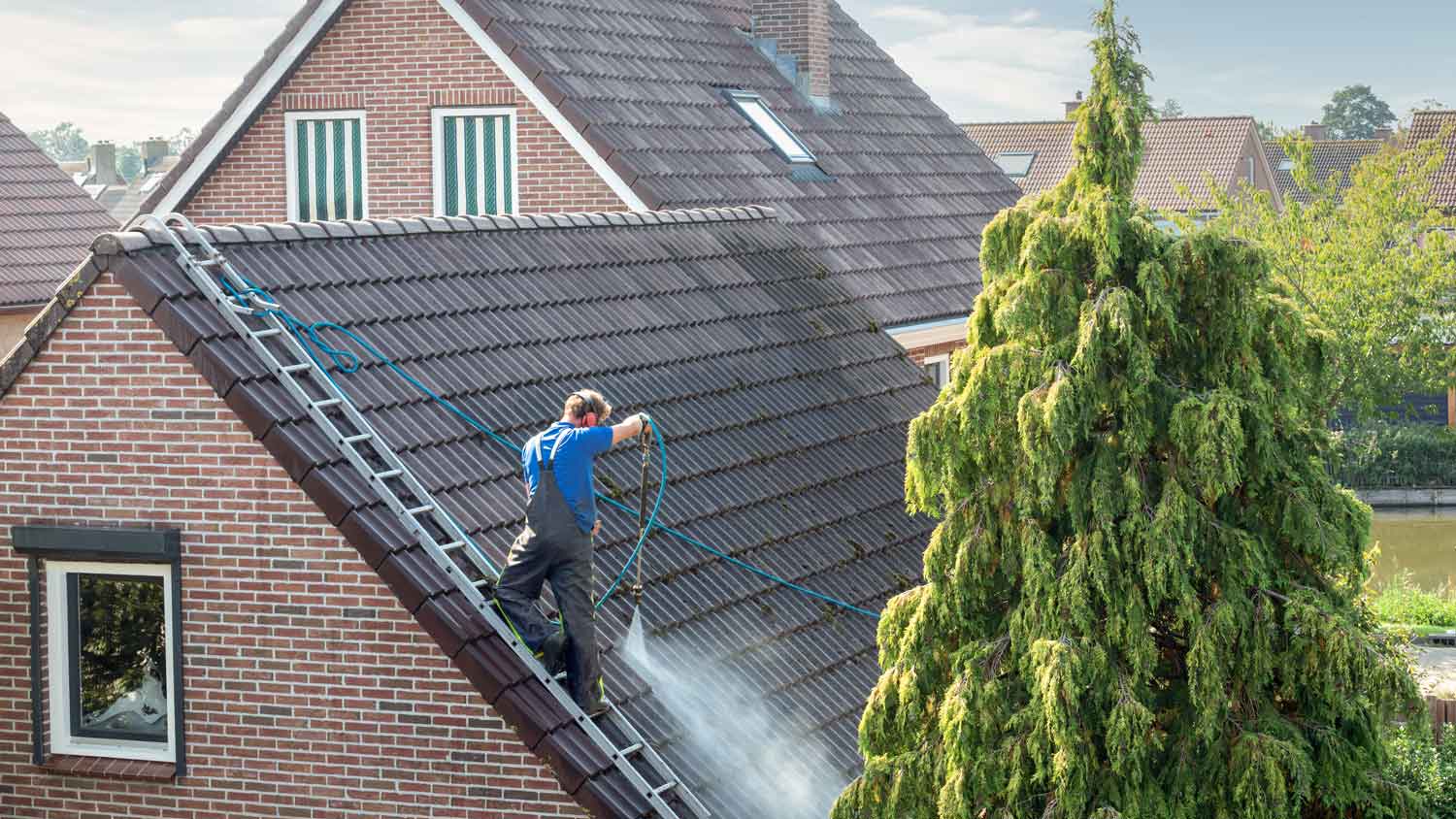 A professional pressure washing a roof