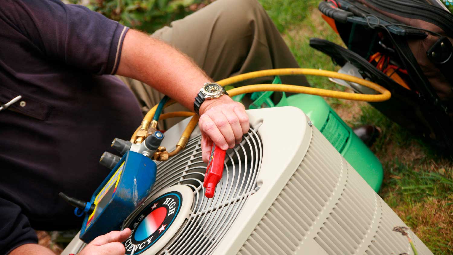 A professional repairing the exterior HVAC unit