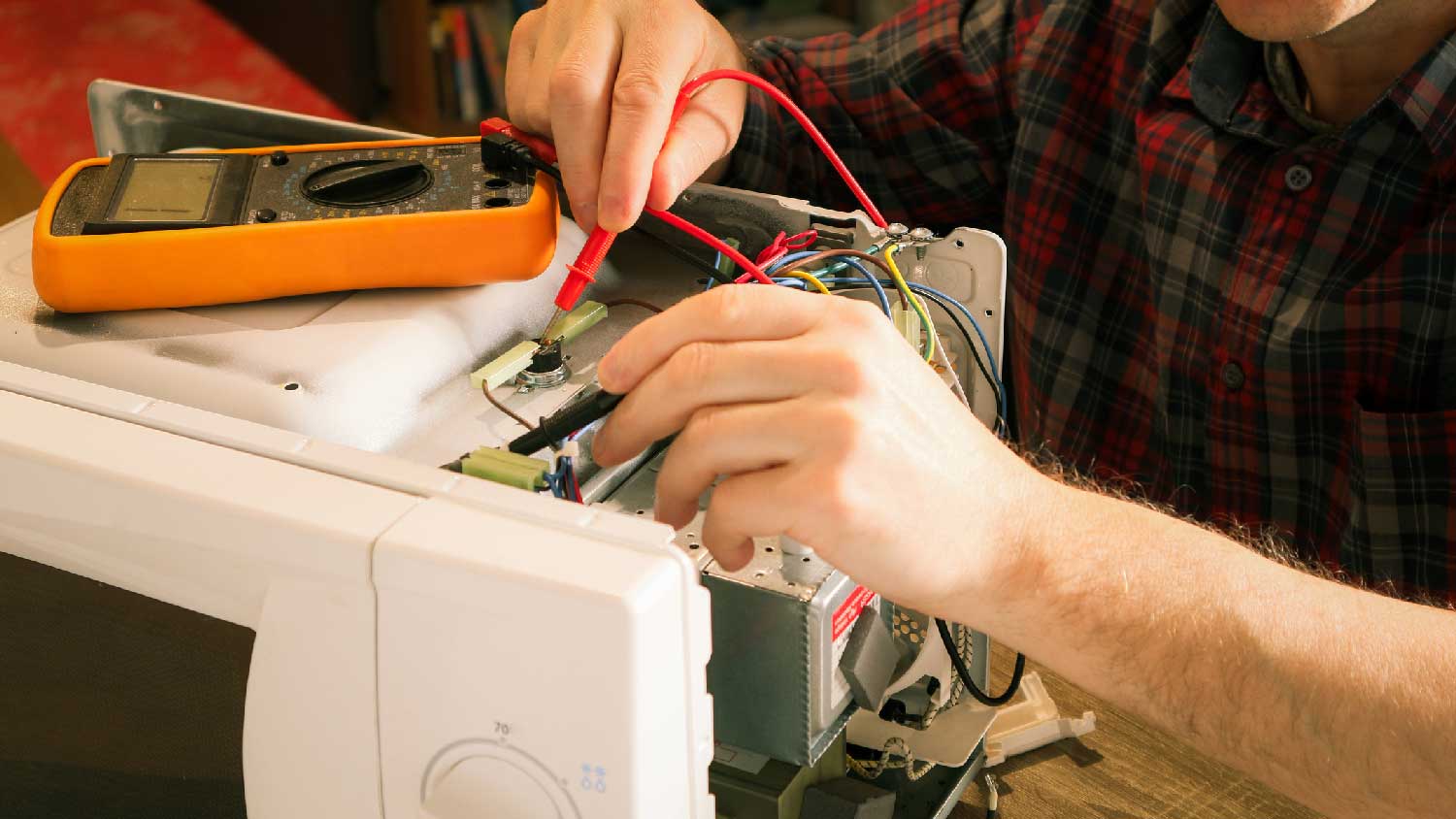A professional repairing a microwave