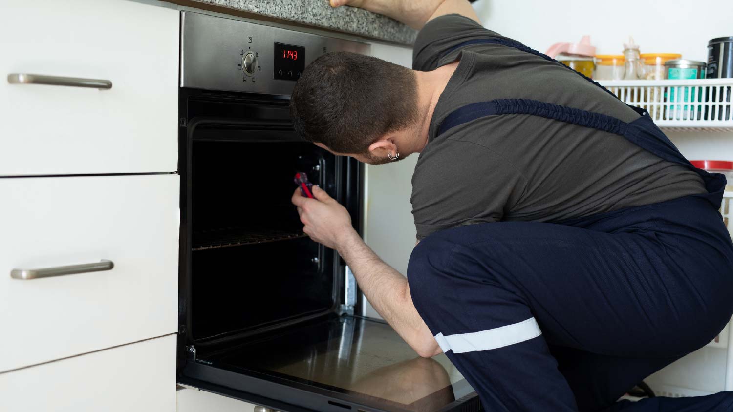 A professional repairing an oven