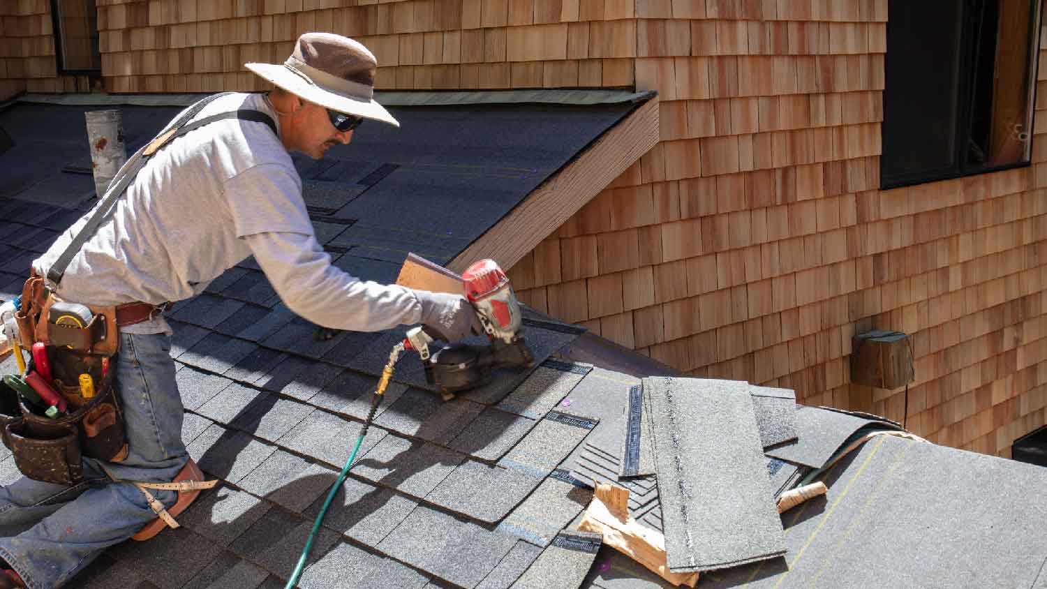 A professional replacing shingles on a roof